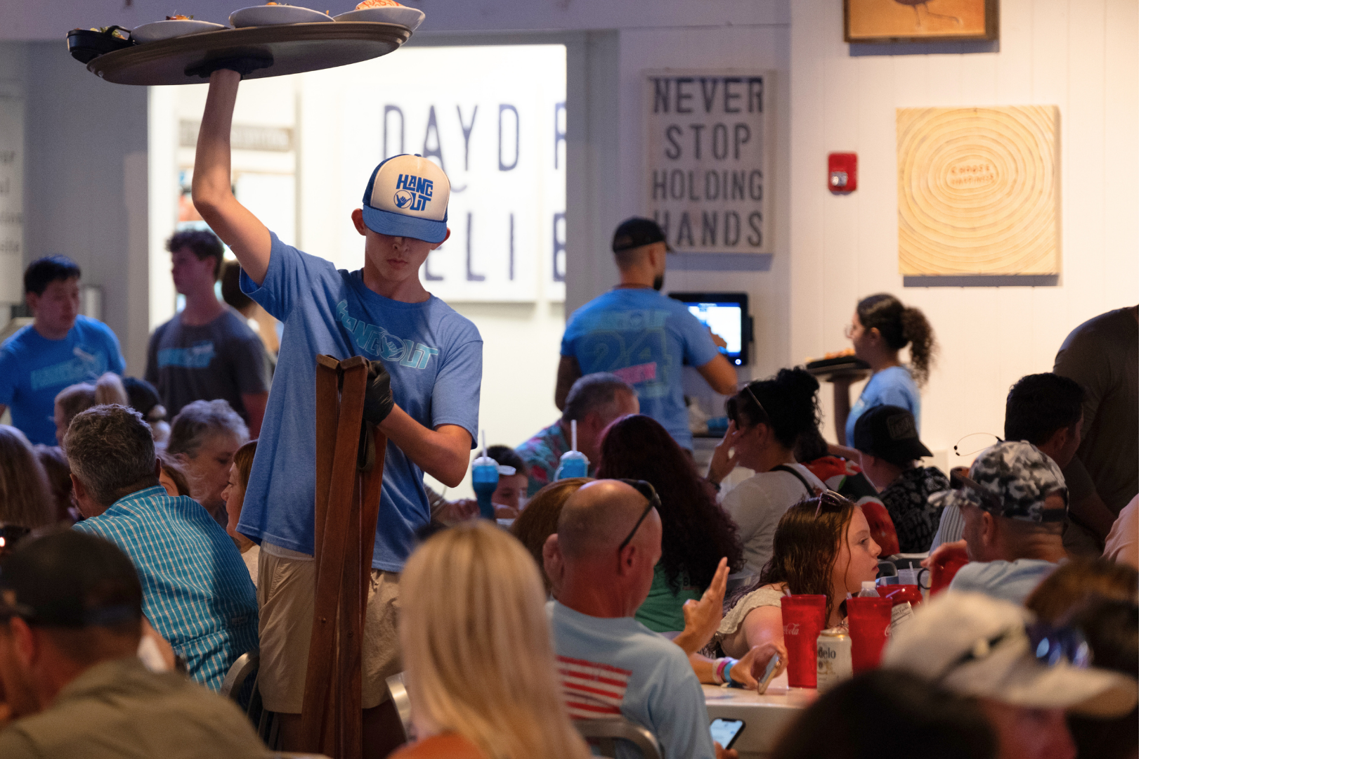 Server carries tray in crowded restaurant
